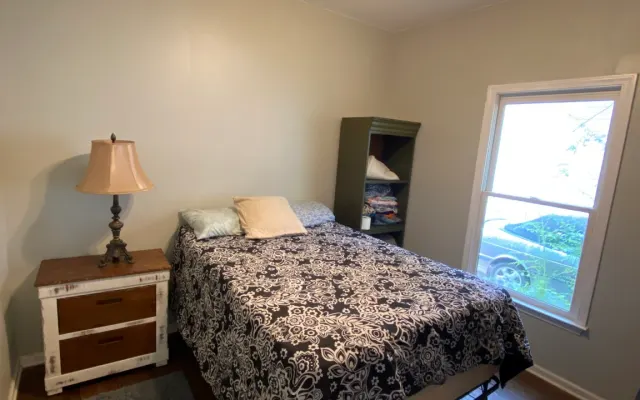 chambre privée avec un grand lit et une salle de bain commune
