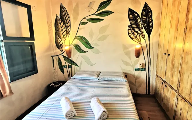 Zweibettzimmer mit Deckenventilator und Seitenfenster.