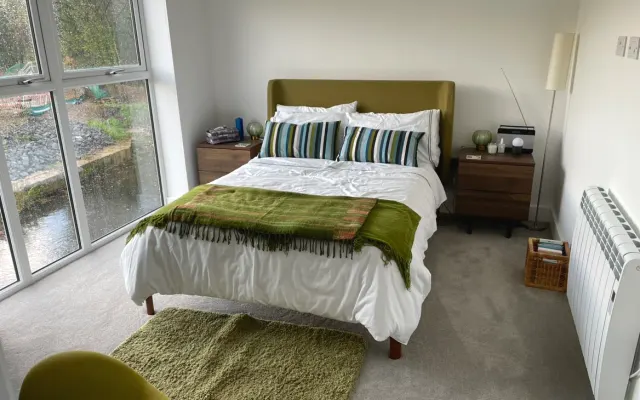 Private double bedroom with adjacent bathroom in a riverside house.