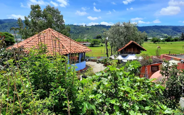 Hermosa cabaña sustentable rodeada de un jardín de arboles frutales