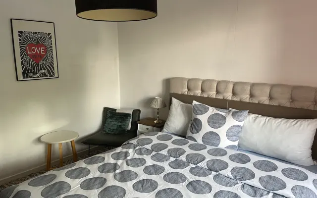 Room with double bed and shared bathroom and kitchen
