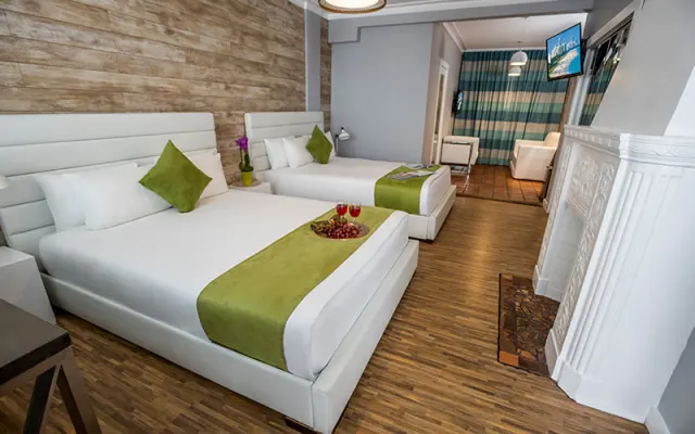 1 lit queen dans une grande chambre avec un coin salon séparé