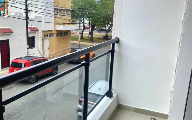 Camera d'albergo con balcone che si affaccia sulla strada e vista...