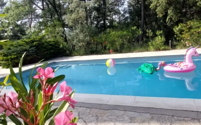 Bela casa aninhada na vegetação com uma grande piscina.