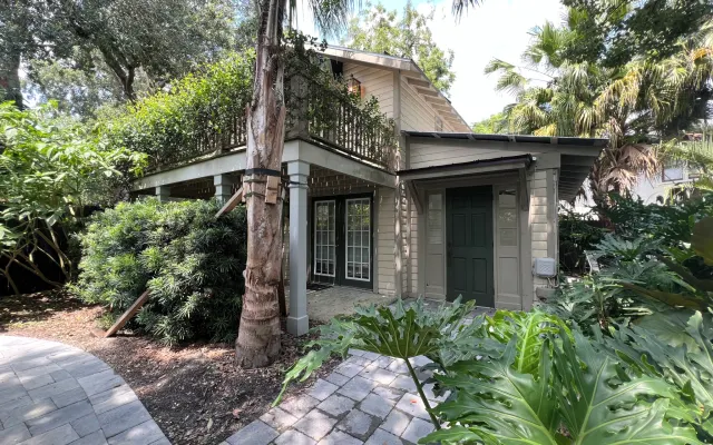 Casa de campo de dois andares rodeada por um jardim tropical