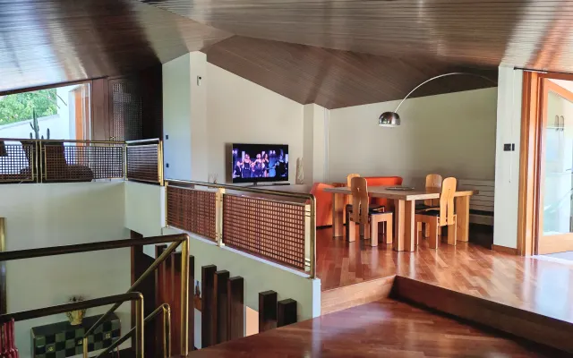 Casa isolada em um bairro residencial, cercada por colinas suaves.