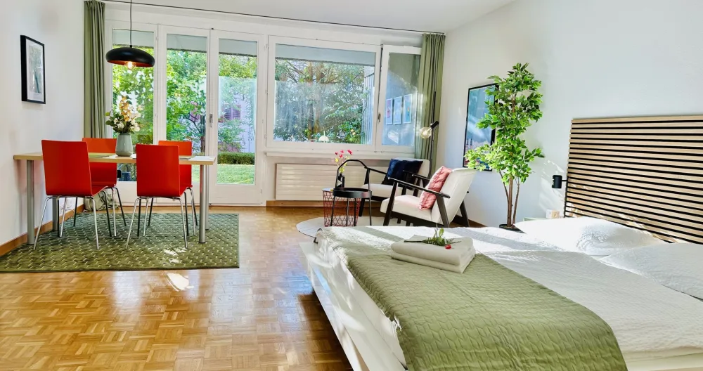 L'annuncio di Thomas su misterb&b - Blick von der Küche auf den grossen Wohnbereich mit gemütlichem Bett, Tisch, Lounge und Zugang zu Terrasse und Garten.