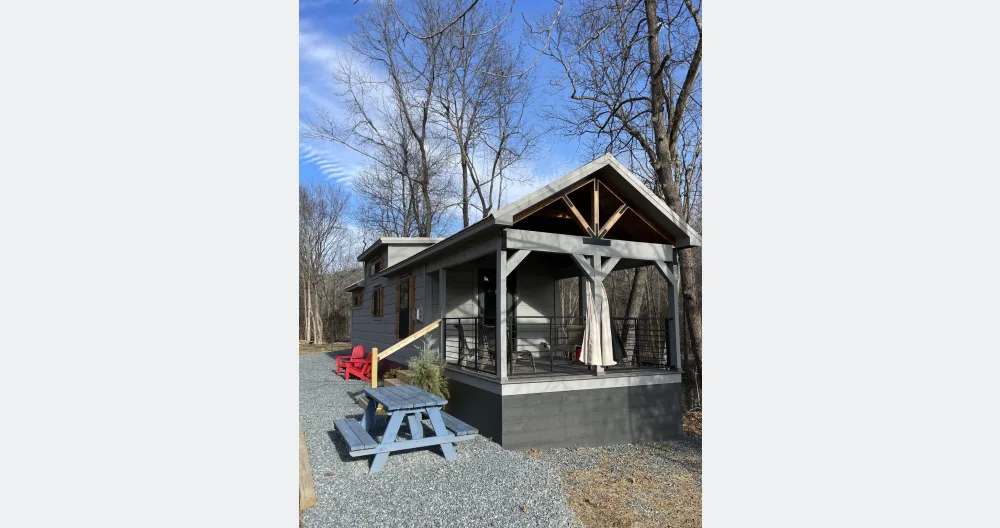 L'annuncio di Jason su misterb&b - The Tiny Whitfield front porch is 12x12 and includes a ceiling fan and curtains for a touch of privacy. Sitting on the edge of our front flower field, it commands the best views. 