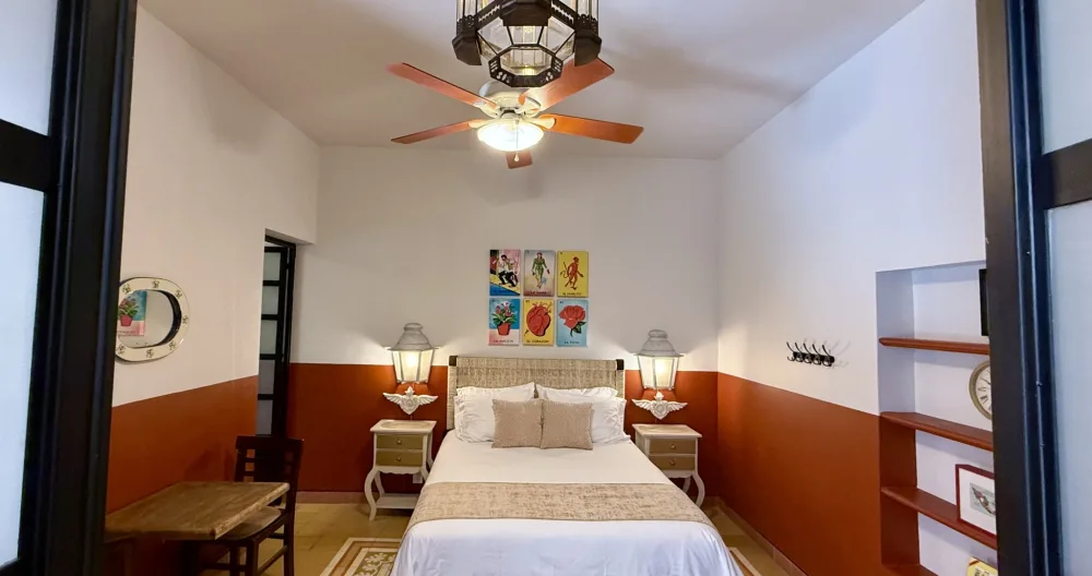 Annonce de Randy sur misterb&b - The Red Room features a queen-sized bed, small sitting area, private en-suite full bath, ceiling fans, floor fan, and tv.