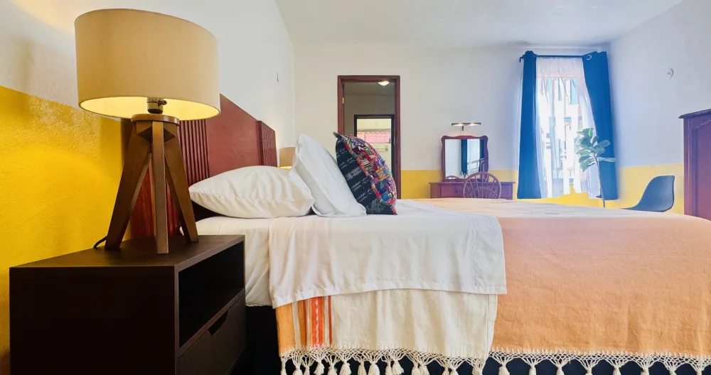 Richies Inserat auf misterb&b - La Habitación Amarilla features a king-sized bed with linen sheets and handmade Oaxaca blankets.