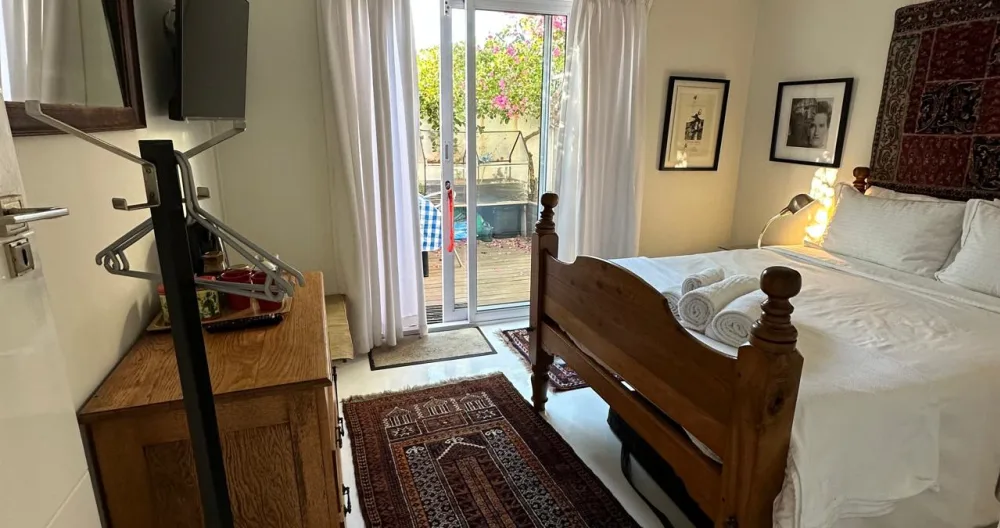 Anúncio de Freddie em misterb&b - Vista da cama do quarto de banho a partir da porta da casa de banho, com o terraço ao fundo
